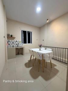 a living room with a white table and chairs at Gassania Hostel in Banda Aceh
