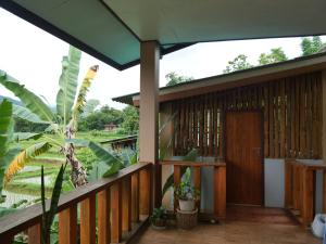 a balcony of a house with a wooden door at นากลางดอย Naklangdoi in Ban Na Kham