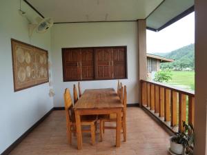 a wooden table and chairs on a balcony at นากลางดอย Naklangdoi in Ban Na Kham