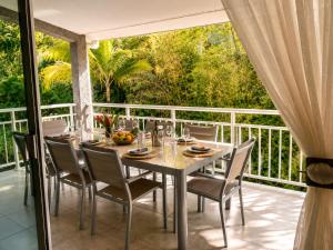 a dining table and chairs on a balcony with a view at Le Nid de Magenta by Gérald Appartement Premium Magenta Terrasse Parking in Noumea