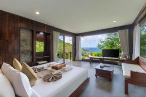 a bedroom with a large white bed and large windows at Tanote Villa resort, Koh-Tao in Ko Tao