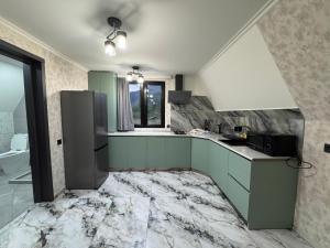 a kitchen with green cabinets and a marble floor at Hiyadel balcony in Sadgeri