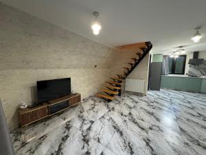 a living room with a staircase and a television at Hiyadel balcony in Sadgeri