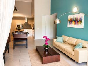 a living room with a couch and a table at Le Nid de Magenta by Gérald Appartement Premium Magenta Terrasse Parking in Noumea