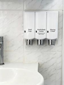 a white bathroom with a toilet and a sink at Coffs Coastal Cabin, Central & Convenient in Coffs Harbour