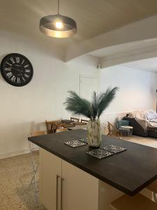 a kitchen and living room with a clock on the wall at Le Cocon d aurélie in Thèzan-lès-Béziers