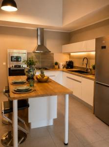 a kitchen with a wooden table and a refrigerator at Le Nid de Magenta by Gérald Appartement Premium Magenta Terrasse Parking in Noumea +6 photos