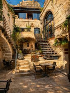 a stone building with stairs and tables and chairs at The Rupestral House Hotel in Uçhisar