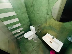 a bathroom with a sink and a toilet and a mirror at Nakshatra in Kovalam +39 photos