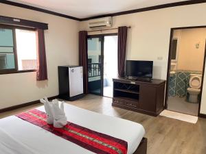 a hotel room with a bed and a tv and a room at Emporium Chiangmai in Chiang Mai