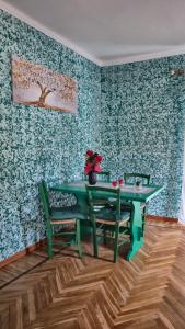 a dining room with a green table and two chairs at La Tana del Ghiro in Condove