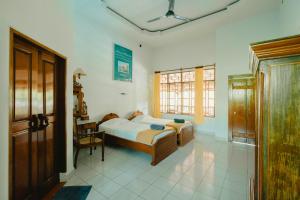 a bedroom with a bed and a table and a window at Uns Hotel - Bali in Legian +41 photos