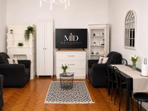 a living room with two black chairs and a table at Mid Ultra Central Apartments, Self Check In in Oradea