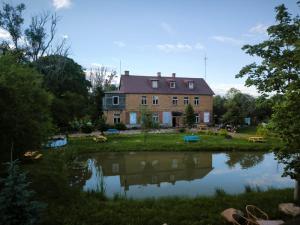 a house with a pond in front of it at Butterfly House in Pāvilosta