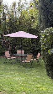 a table and chairs with an umbrella on the grass at Master suite en Teotihuacan in San Sebastian Xolalpa +7 photos