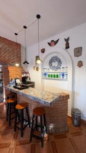 a kitchen with a brick counter and stools at Master suite en Teotihuacan in San Sebastian Xolalpa