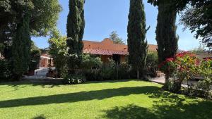 a house with a yard with trees and grass at Master suite en Teotihuacan in San Sebastian Xolalpa