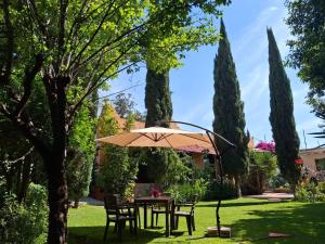 a table with an umbrella in a garden at Master suite en Teotihuacan in San Sebastian Xolalpa
