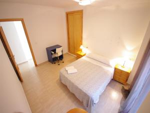 タリファにあるLivingtarifa Apartamento Blue IIの小さなベッドルーム(ベッド1台、デスク付)