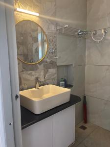a bathroom with a white sink and a mirror at Burnside Cottage in Kotagiri +58 photos