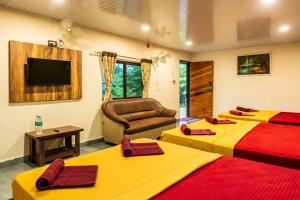 a hotel room with two beds and a television at Green Nest Resorts in Malebennūr