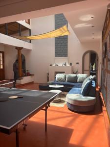 a living room with couches and a pool table at Burnside Cottage in Kotagiri