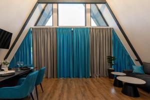 a living room with a large window with blue curtains at Devi retreat in Arpaşu de Sus