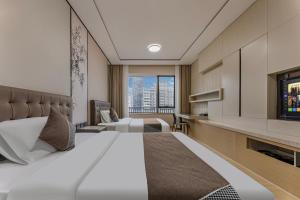 a hotel room with a large bed and a tv at East Station Boya Hotel in Guangzhou