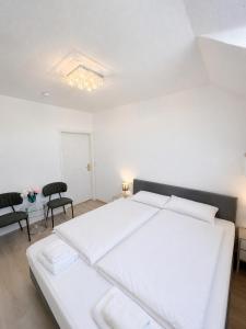 a bedroom with a white bed and a table and chairs at Einzelzimmer am Rheim Nierstein in Nierstein