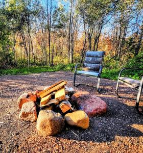 a chair and a pile of rocks and a pile of logs at Maple Grove Lodging in Finland