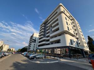 a large white building with cars parked in a parking lot at Montenegro Suite Rental in Bar