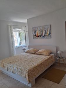 a bedroom with a bed with sailboats on the wall at Apartments Zlata In the Heart of the Old Town, Close to the Beach in Rab