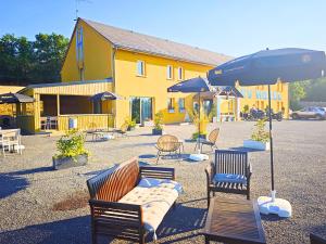 a group of chairs and tables and an umbrella at Sev'hotel in Sévérac-le-Château +5 photos