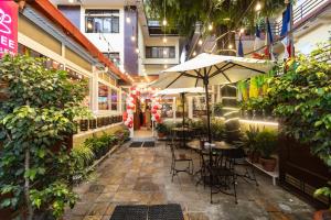a patio with tables and umbrellas in a building at Aryatara Kathmandu Hotel in Kathmandu
