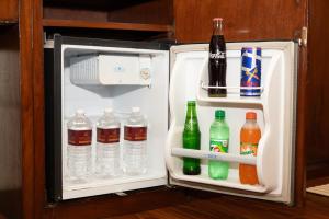 an open refrigerator with bottles of water and drinks at Aryatara Kathmandu Hotel in Kathmandu