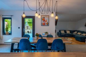 a dining room with a table and blue chairs at Chez Simone Liège, bain nordique in Boncelles