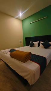 a large bed in a room with a green wall at Melody Stays Inn in Chennai