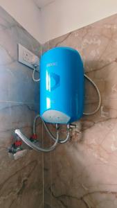 a blue water heater in a bathroom with a wall at Melody Stays Inn in Chennai