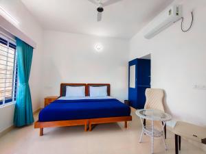 a bedroom with a blue bed and a glass table at Avanthi Homestay in Varkala +52 photos