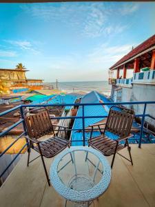 a balcony with two chairs and a table and the beach at Avanthi Homestay in Varkala