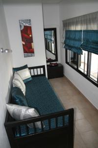 a small bedroom with a bed and two windows at Pedras Del Rei Holiday House in Tavira