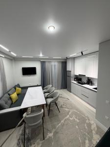 a living room with a couch and a table and chairs at Townhouse Atlantis Resort in Chetkoysu