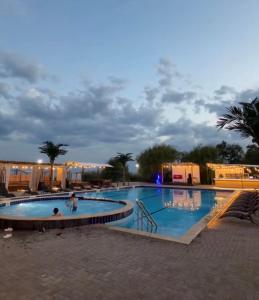 a large swimming pool with people in it at night at Townhouse Atlantis Resort in Chetkoysu