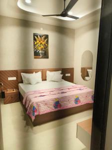 a bedroom with a large bed with a pink blanket at Hotel 9Eleven & Cafe in Barnāla