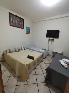 a bedroom with a bed and a flat screen tv at durmaaquislz2 in São Luís