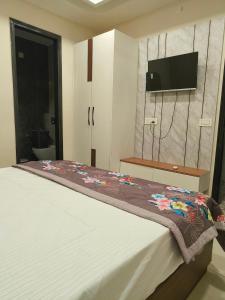 a bedroom with a bed with a floral blanket on it at Hotel 9Eleven & Cafe in Barnāla