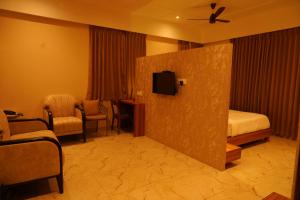 a hotel room with a bed and a tv at Hotel river view sringeri in Sringeri