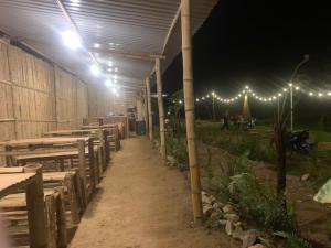 a row of tables and benches in a building with lights at Aluoi Homestay in Hue