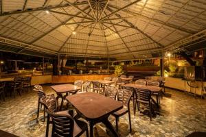 a restaurant with tables and chairs and a large ceiling at Rain Forest Jungle Stay in Kurandi