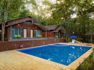a swimming pool in front of a house at Rain Forest Jungle Stay in Kurandi